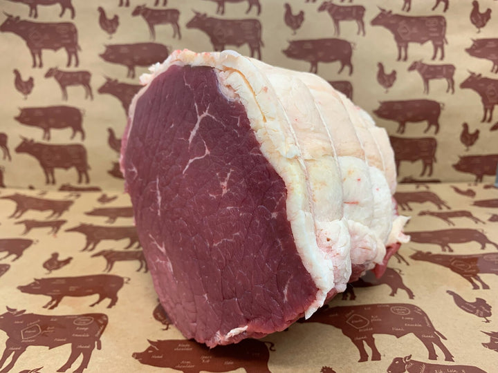 A David Moore's beef topside, trimmed with a thick layer of white fat and bound with twine.