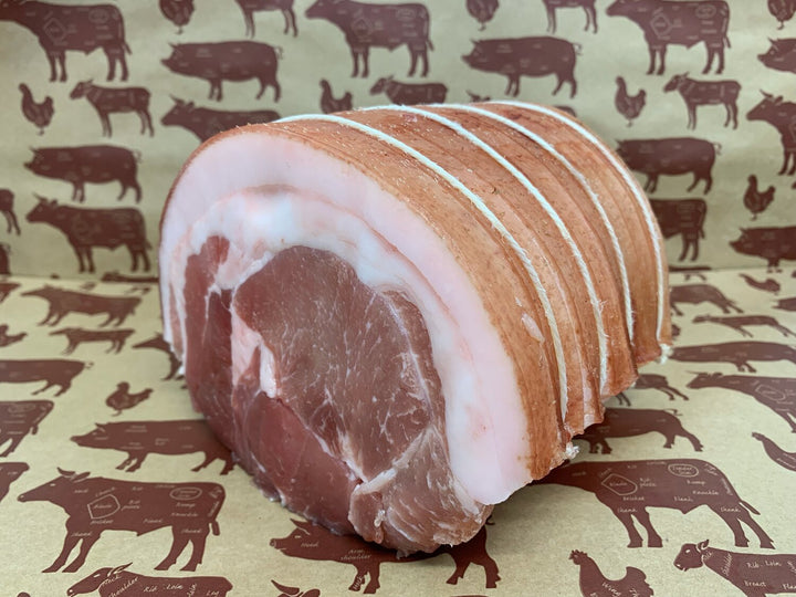 A David Moores fresh free-range pork loin joint with a layer of scored fat, tied with string.