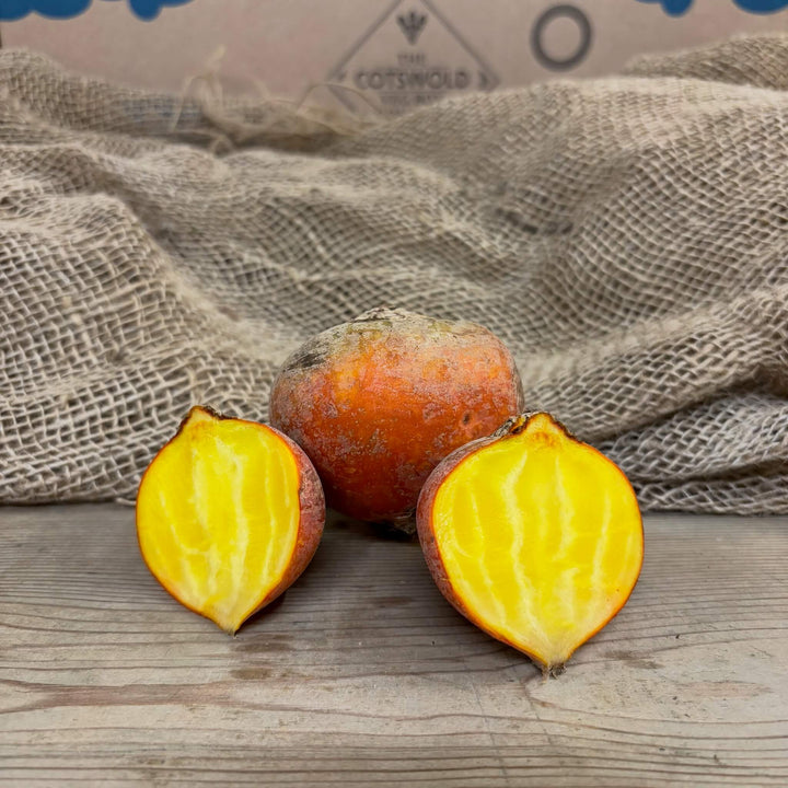 A golden beet with two halves revealing vibrant yellow flesh centre. 